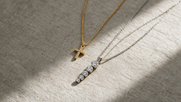 Axiom cross pendant and Rhapsody five-stone pendant laid out at different lengths