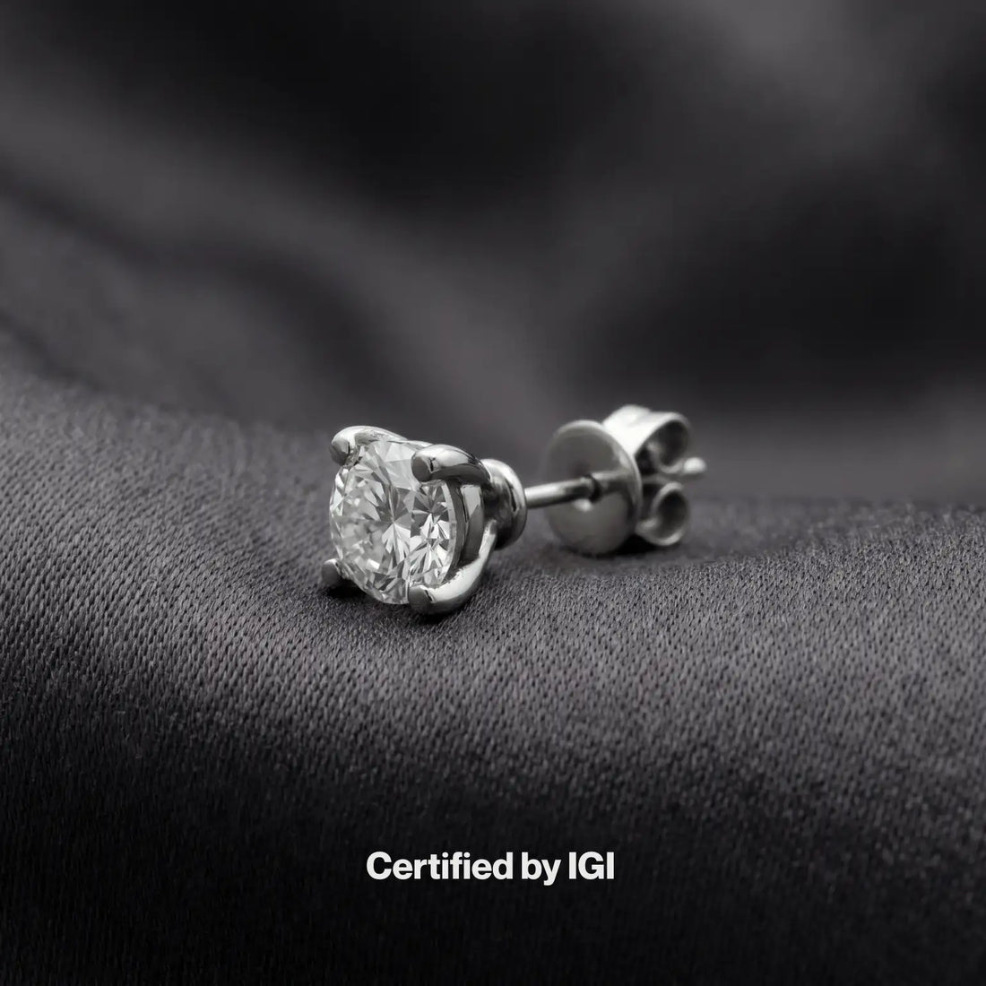 Close-up of a man wearing a diamond earring with a neutral background