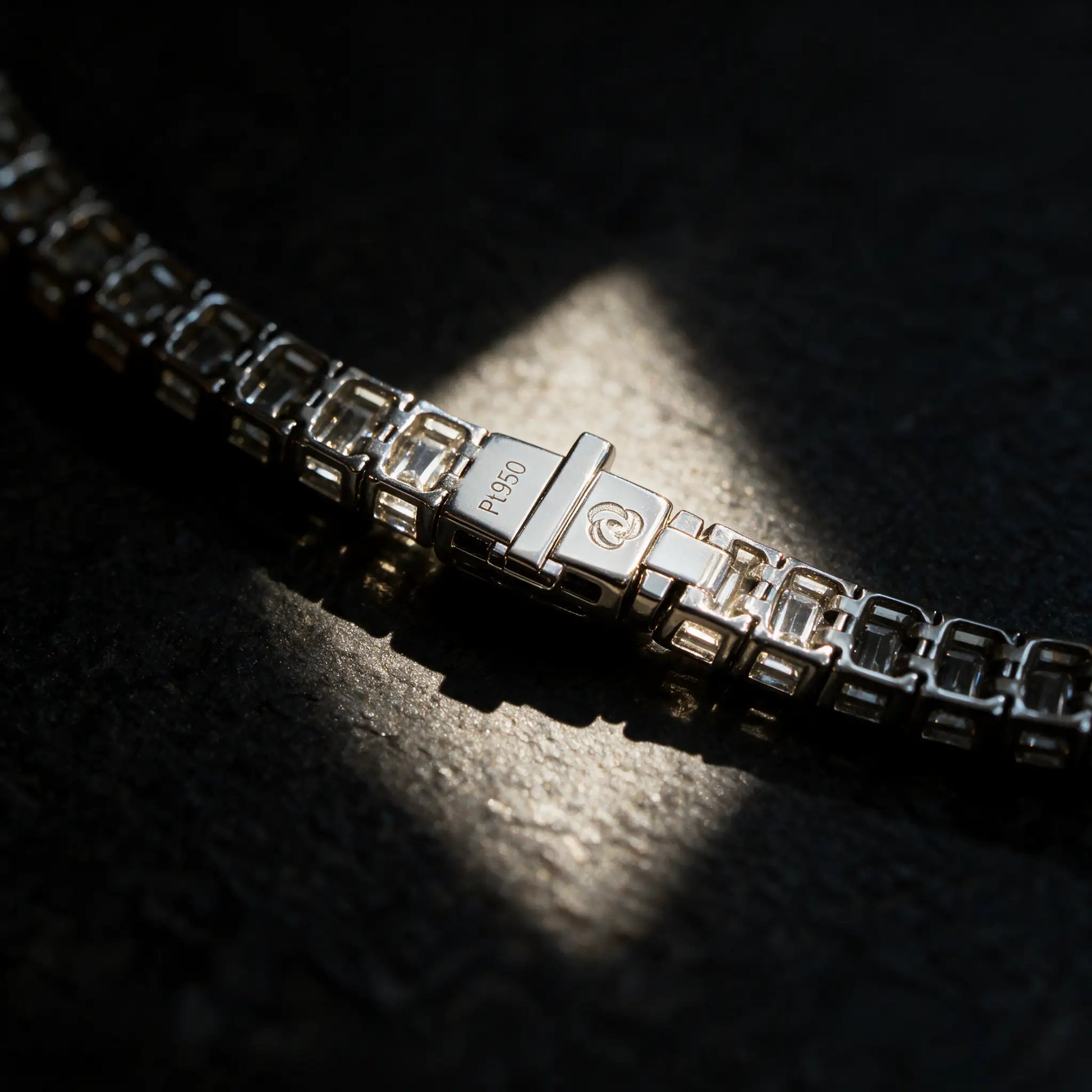 Angled view of the clasp back showing the Pt950 hallmark and maker's mark on the Meridian emerald cut lab grown diamond tennis bracelet by Carat Club Co.
