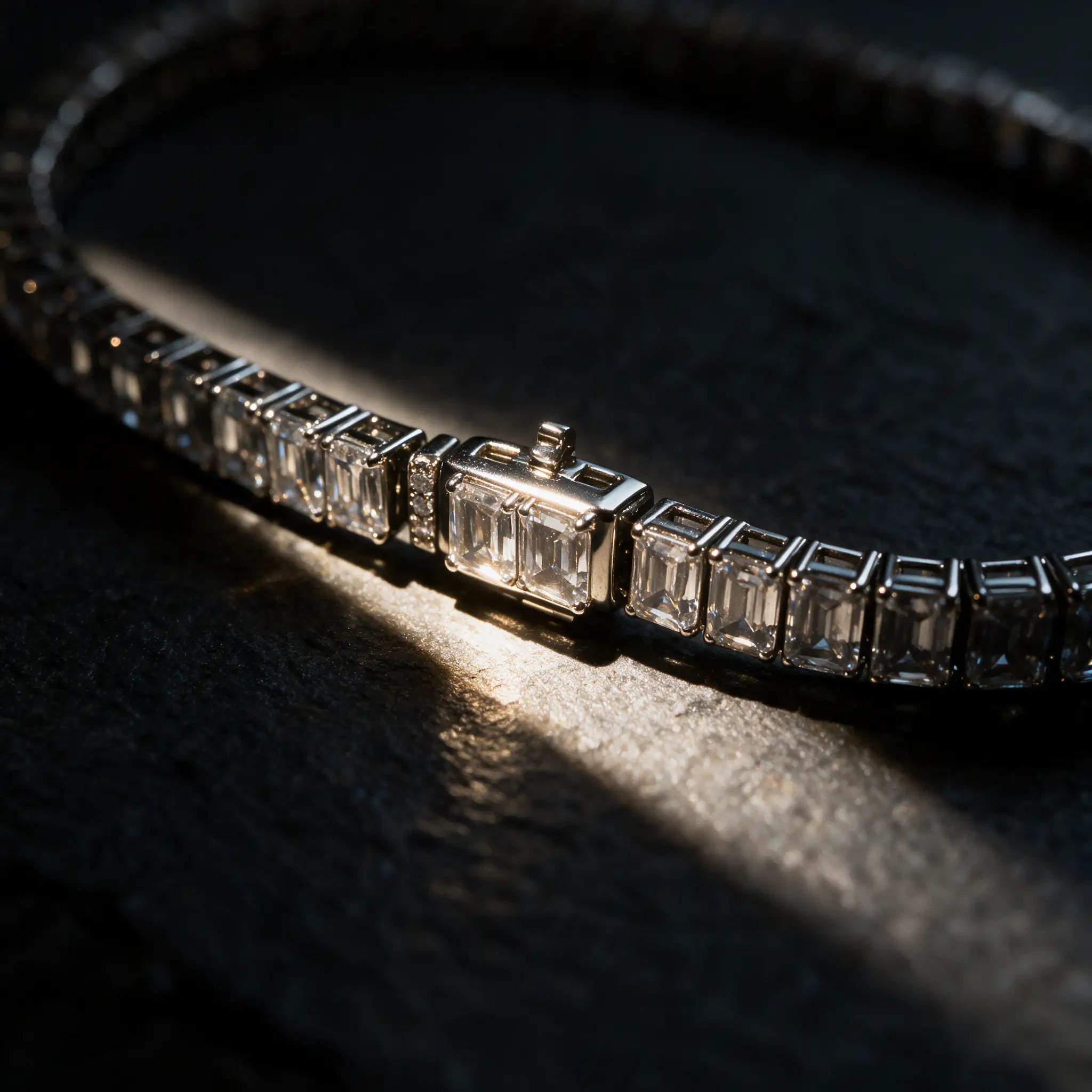 Front clasp detail of the Meridian emerald cut lab grown diamond tennis bracelet by Carat Club Co., showing the integrated clasp set in the diamond line with a column of small round accent diamonds.